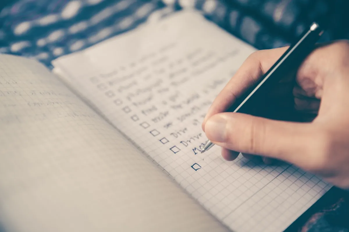 Taccuino aperto con checklist e penna per pianificare l'apertura della partita IVA